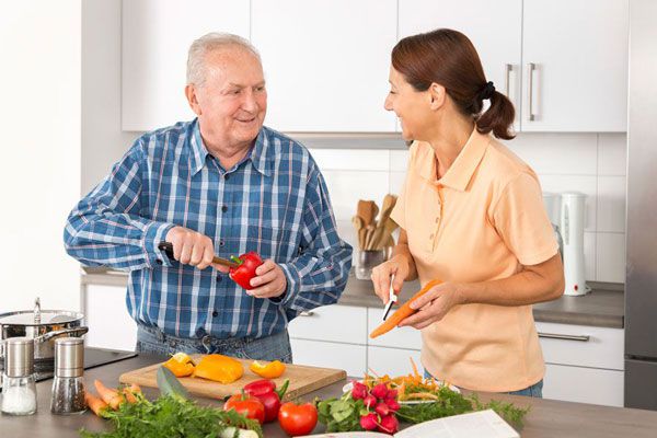 An image of two people peeling vegetables